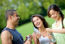 Athletic people holding bottles of water outdoors