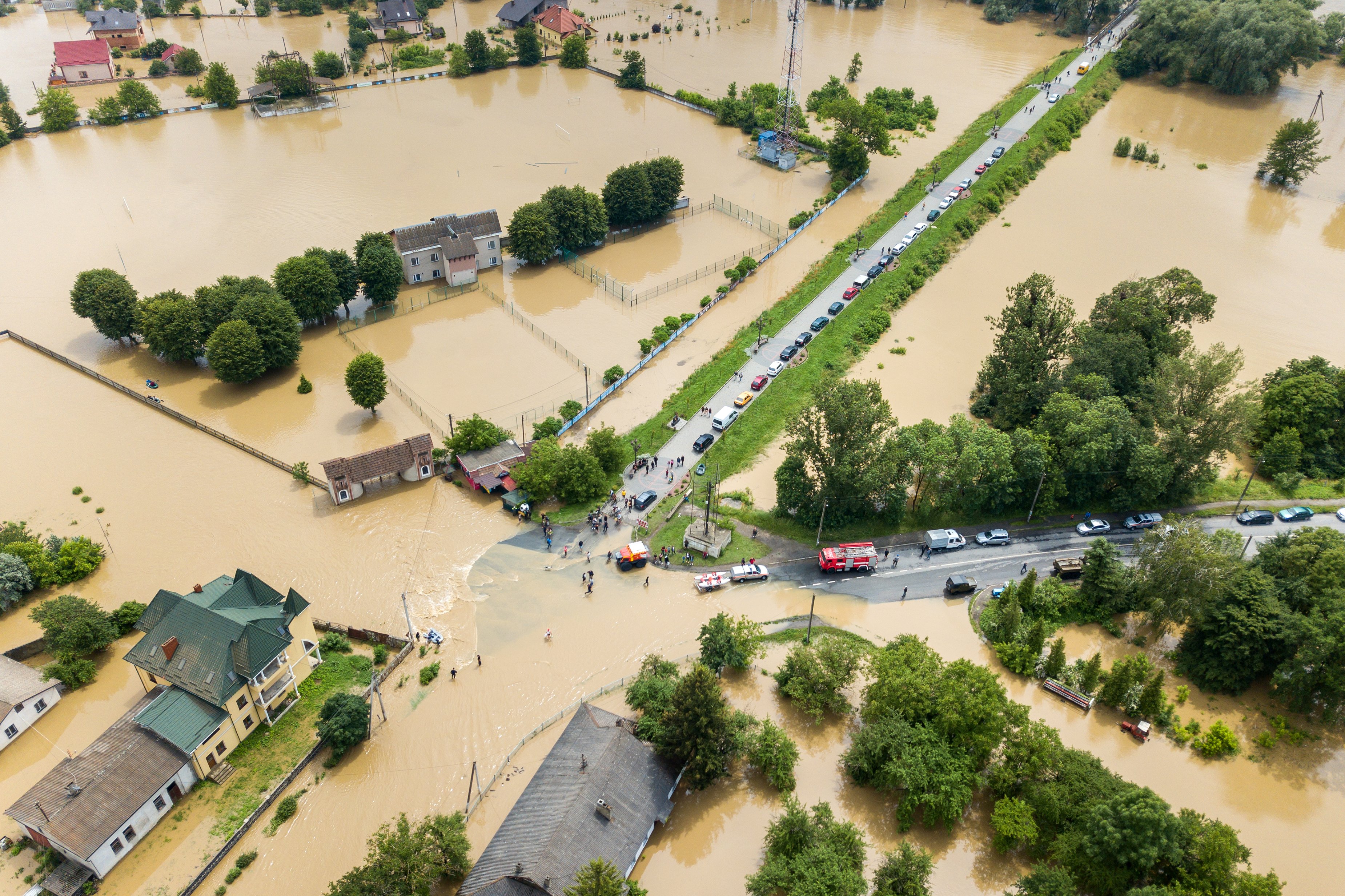 aerial view of flooded houses and rescue vehicles