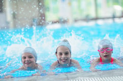 group of happy kids children   at swimming pool class  learning to swim